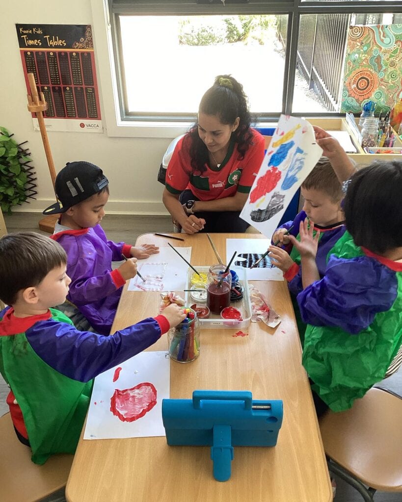 Educator and children painting