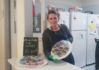 An educator holding up baked goods