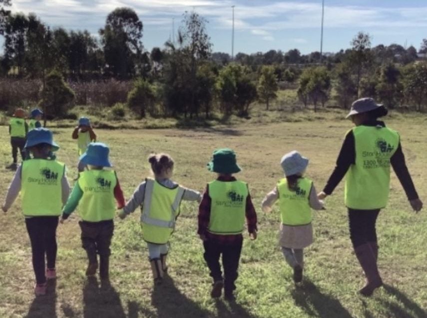 children outside walking and holding hands