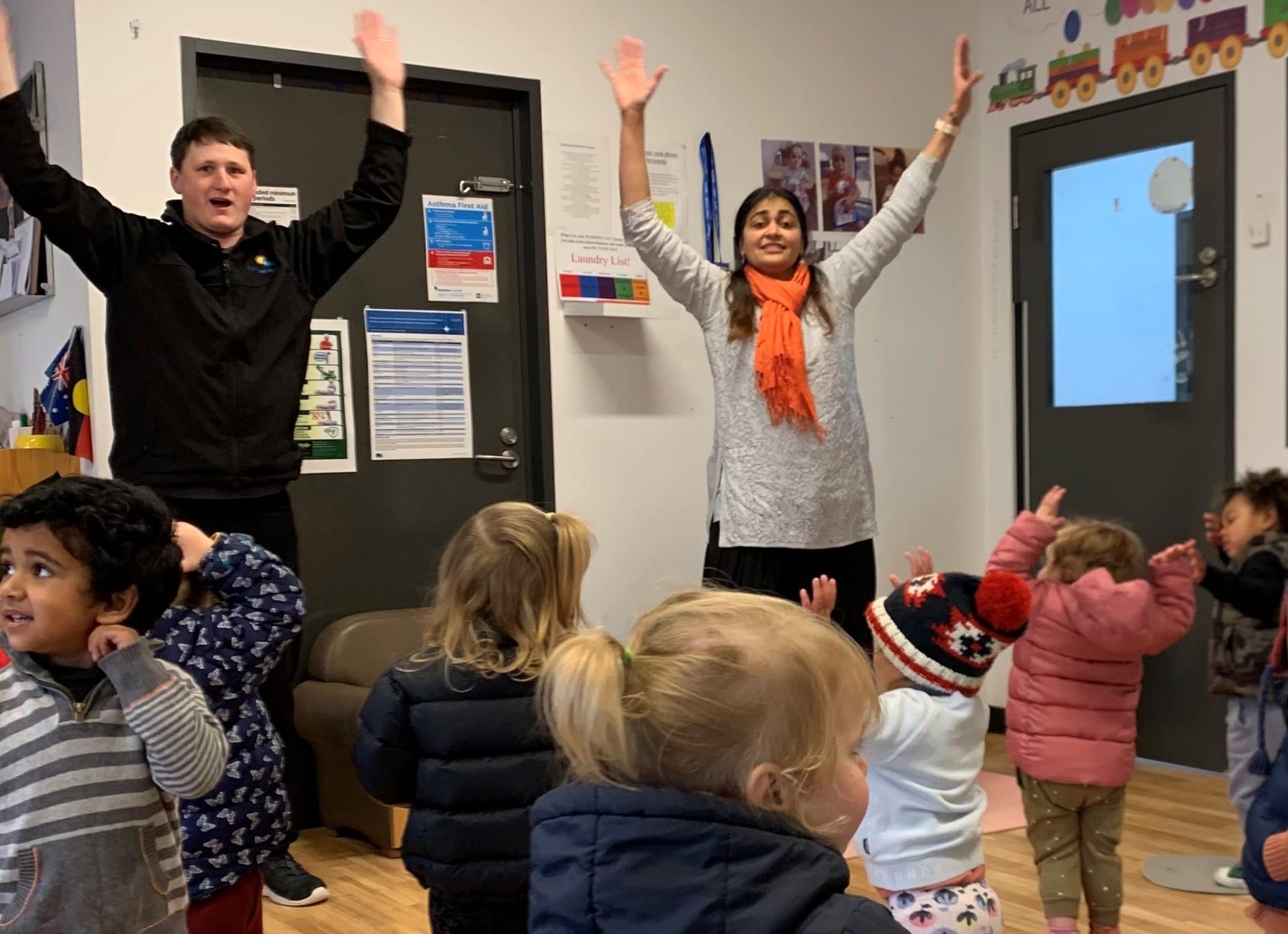 Children being instructed to hold their hands in the air as part of a connecting mind, body and breathing session