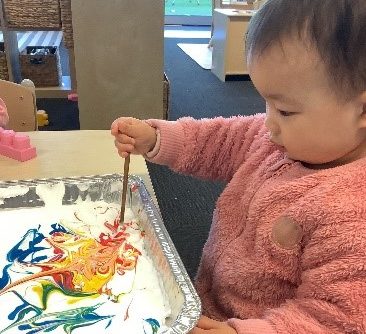 A young child exploring colours at Story House Mascot