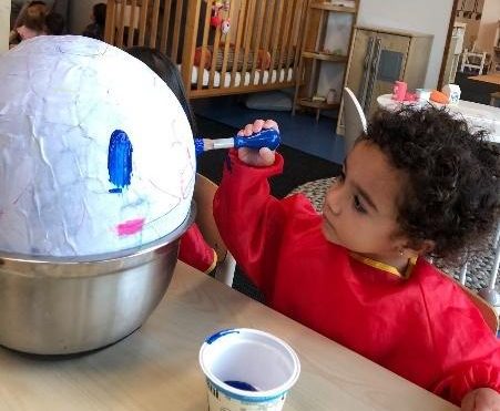 A child painting on papier-mache